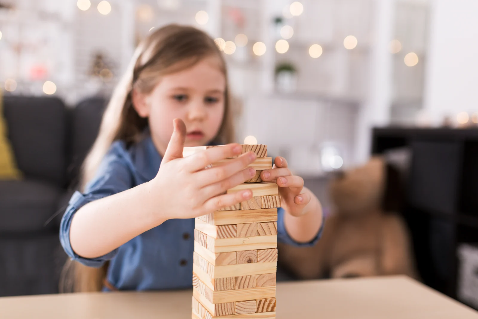 Girl building a tower from wooden blocks